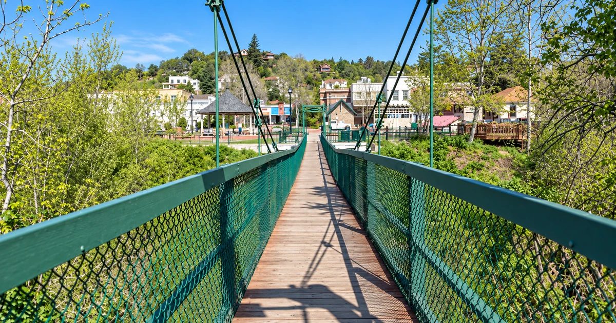Pedestrian swinging bridge over Arroyo Grande Creek with the Village of Arroyo Grande beyond