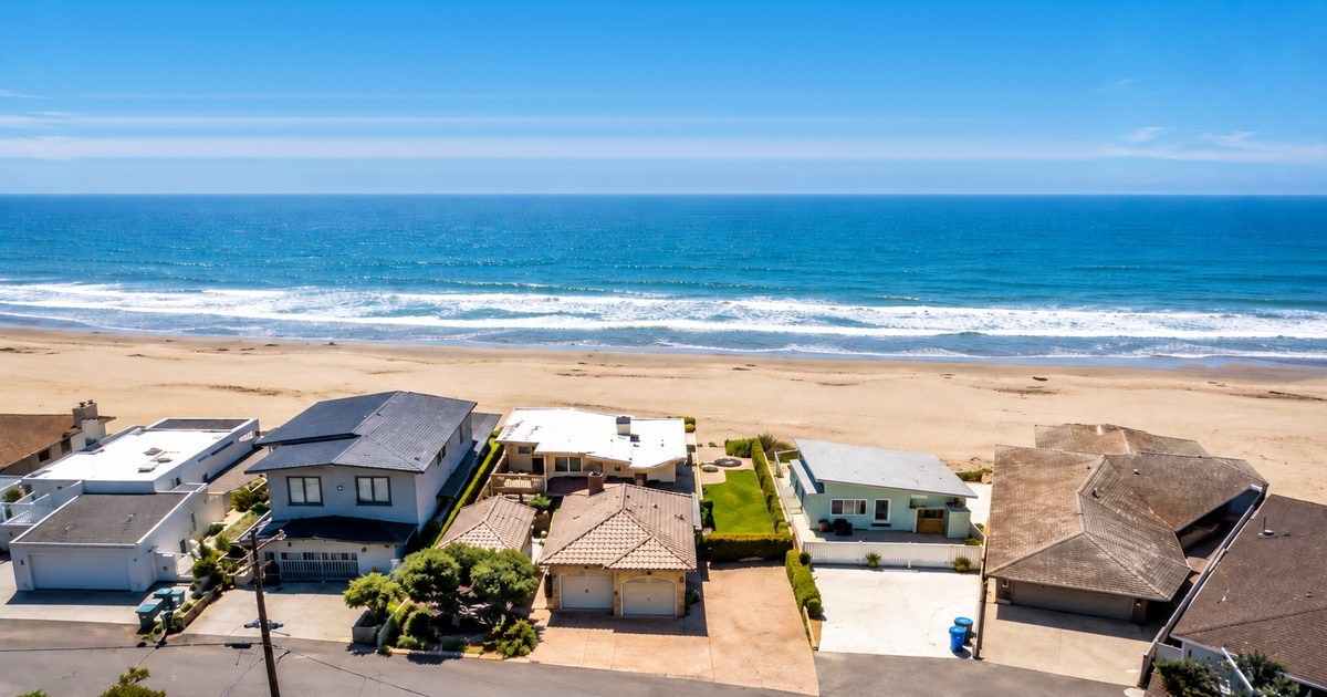 Aerial view of beachfront homes on the sand in San Luis Obispo County, where a coastal development permit is required