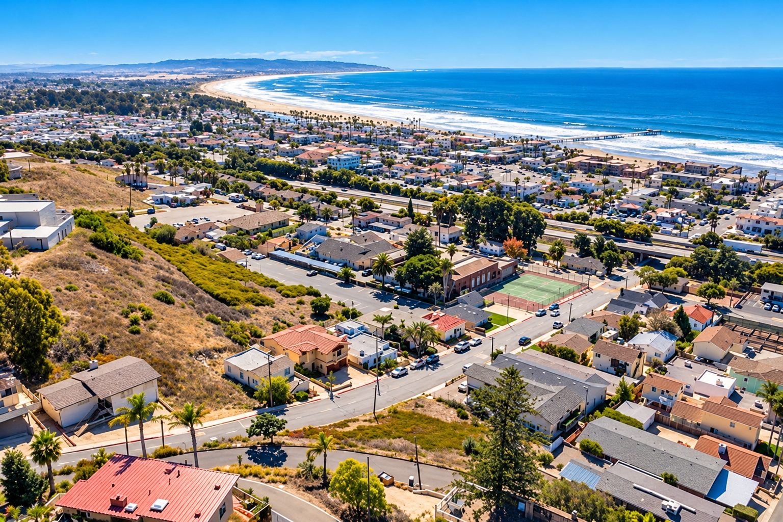 Aerial view of Pismo Beach homes, the pier, and the coastline for buyers moving to Pismo Beach